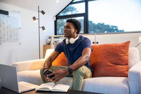 Young man relaxing with technology in modern living space