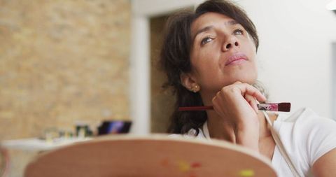 Contemplative Artist Pondering Over Creative Work at Home