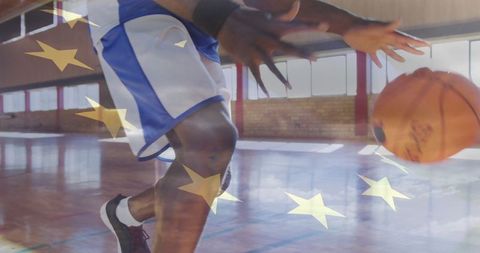Athletic basketball player dribbling on indoor court