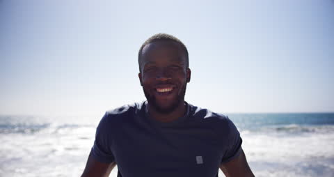 Smiling Man Enjoying Beachfront on Sunny Day
