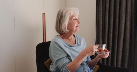Senior Woman Relaxing at Home with Tea in Cozy Setting