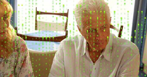 Senior couple talking at home table with green binary code overlay representing digital life