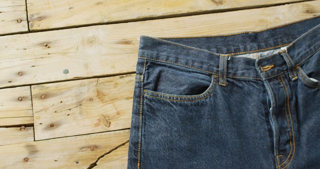Close up of jeans on wooden background with copy space. Denim day, material, style and design concept.