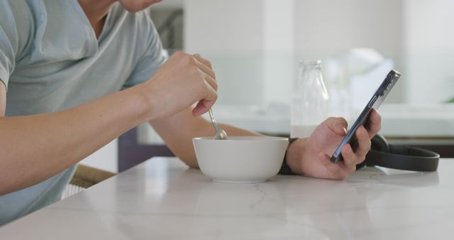 Person Eating Breakfast While Using Smartphone at Kitchen Counter - Download Free Stock Images Pikwizard.com