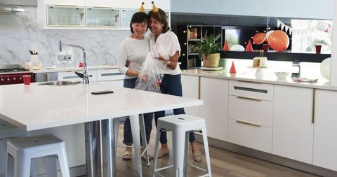 Senior Female Friends Tidying After Joyful Birthday Celebration