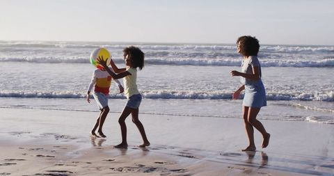 Family enjoying beach activities with inflatable ball