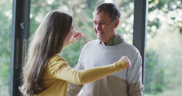Happy senior caucasian father and teenage daughter hugging by window with garden view - Download Free Stock Photos Pikwizard.com