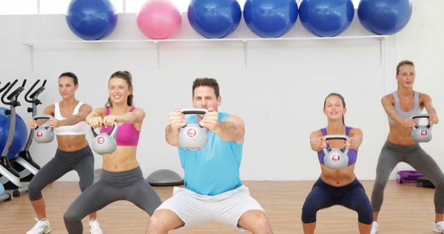 Group fitness class performing kettlebell squats in gym - Download Free Stock Images Pikwizard.com