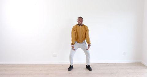 Fit African American Man Practicing Indoor Squats