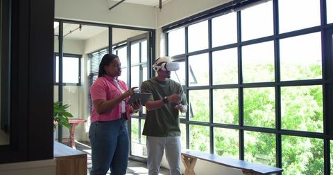African american coworkers testing virtual reality prototype in sunlit modern office