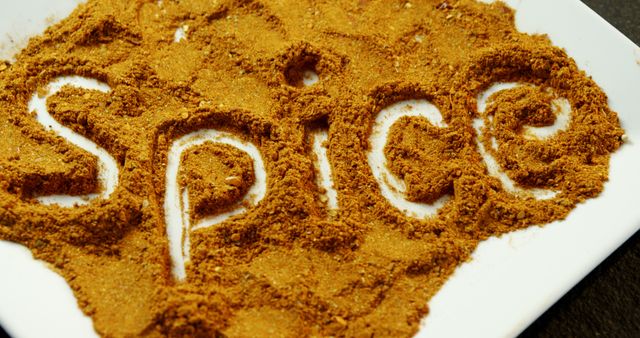 Ground spices are spread out on a surface with the word SPICE written in it, with copy space. It suggests a culinary theme, emphasizing the importance of spices in cooking and flavor enhancement.
