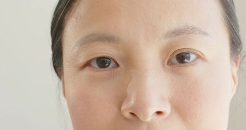 Closeup portrait asian woman showing natural skin texture and calm neutral expression