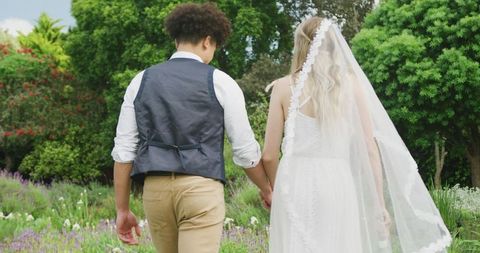 Diverse Couple Celebrating Garden Wedding Hand in Hand