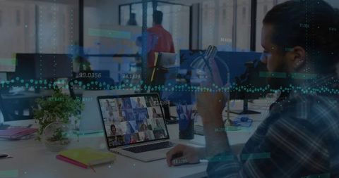 Mid-age professional holding mug, viewing laptop video meeting with analytics overlay