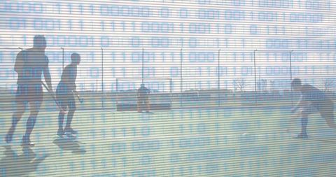 Field hockey players practicing on outdoor turf with binary code overlay for tech-enhanced training