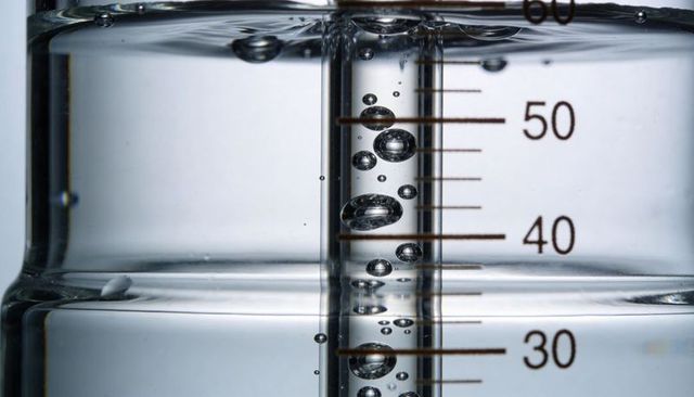 Macro view of measuring cylinder showing aligned air bubbles between 30 and 50 markings