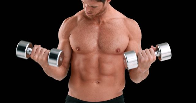 A young Caucasian man is focused on his workout, lifting dumbbells to strengthen his biceps, with copy space. His muscular physique and intense expression underscore a commitment to fitness and bodybuilding.