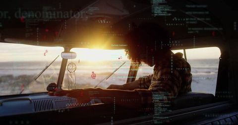 Man Driving Retro Van at Beach Sunset with Digital Code Overlay