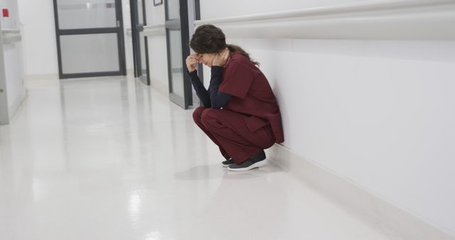 Stressed Medical Professional Sitting in Hospital Hallway - Download Free Stock Images Pikwizard.com