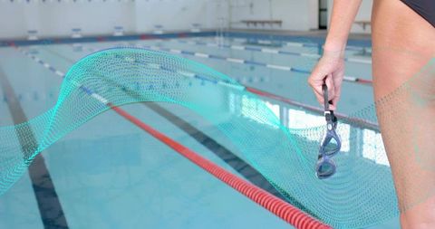 Standing Swimmer Holding Goggles Beside Competition Pool With Teal Wave Graphic