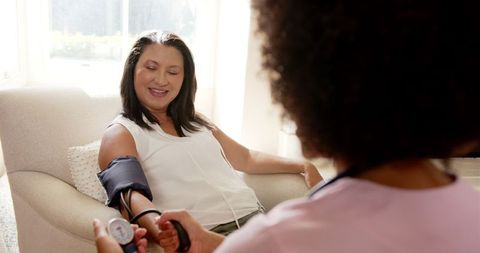 Nurse Checking Blood Pressure for Woman at Home during Wellness Visit