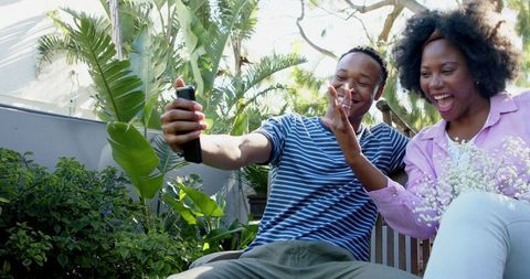 Happy Couple Taking Selfie in Lush Garden Setting