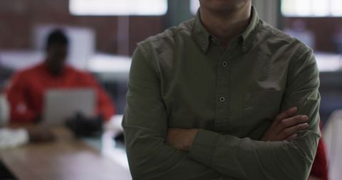 Confident Businessman Crossing Arms in Modern Office