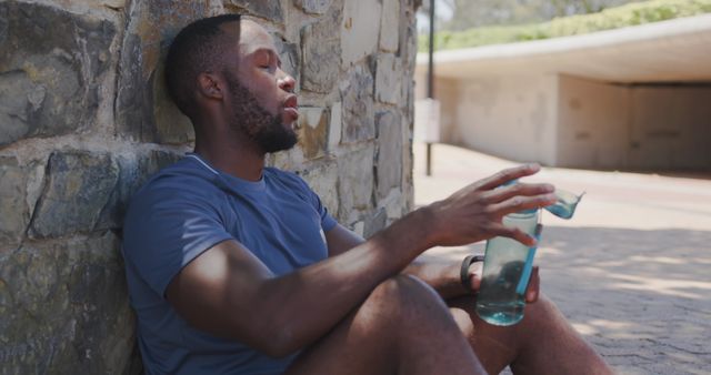 Exhausted Athlete Resting Against Wall with Water Bottle - Download Free Stock Images Pikwizard.com