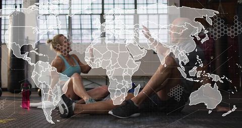 High-fiving gym partners celebrating workout victory with world map overlay and hex grid