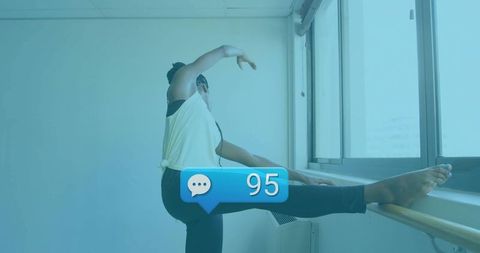 Ballet Dancer Stretching by Barre in Urban Studio