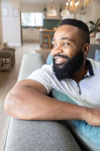 Happy man relaxing on sofa in contemporary living room