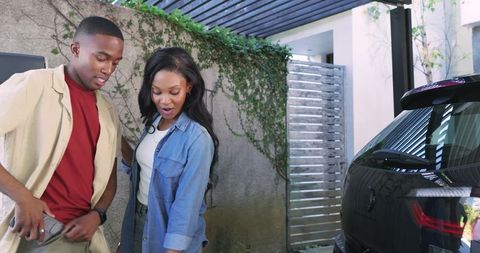 Couple using bluetooth key fob by car