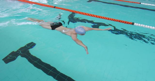 Professional Swimmer Focusing on Perfect Stroke in Indoor Pool - Download Free Stock Images Pikwizard.com