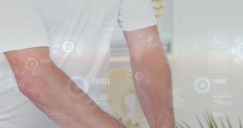 Male forearms leaning on clinic table wearing white polo with holographic hud overlay