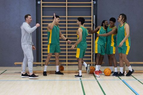 Diverse Basketball Team Celebrating Achievement on Court