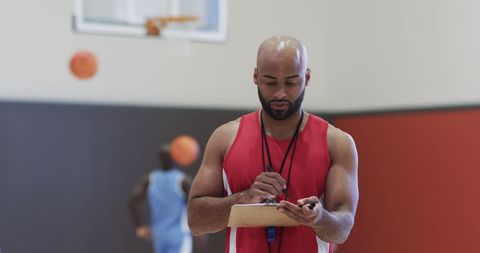 Basketball coach analyzing strategy on indoor court