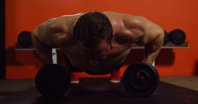 Muscular man performing push-up exercise with dumbbell in gym 4k - Download Free Stock Photos Pikwizard.com