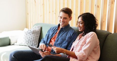 Diverse couple using tablet for online shopping