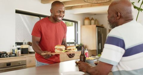 Cheerful Bonding During Homemade Burger Sharing in Kitchen - Download Free Stock Images Pikwizard.com