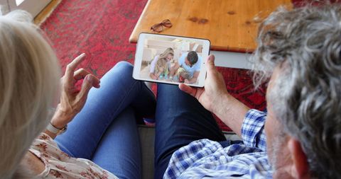 Senior Couple Using Tablet for Video Call with Family