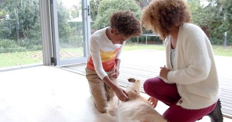Mother and Son Bonding with Dog in Bright Living Room