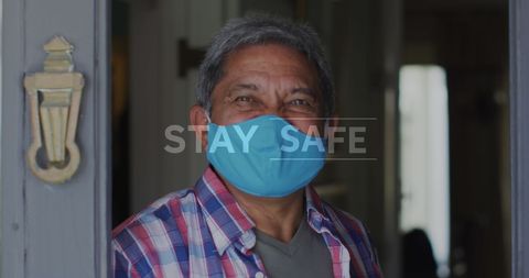 Older Man in Checkered Shirt Smiling with Mask at Doorway
