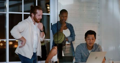 Diverse Team in Night Office Meeting Discussing Ideas