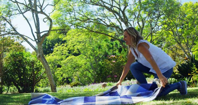 Woman Spreading Picnic Blanket in Park with Trees - Download Free Stock Images Pikwizard.com