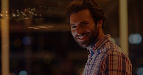 Smiling Businessman with City Lights Reflection