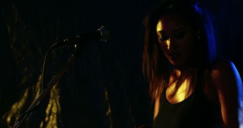 Intimate Live Music Performance by Female Singer on Dim Stage
