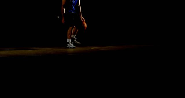 Athlete in a dark gym, with copy space. Low-light setting emphasizes the intensity of sports training.