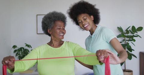 Senior Woman Exercising with Physiotherapist in Home Health Setting