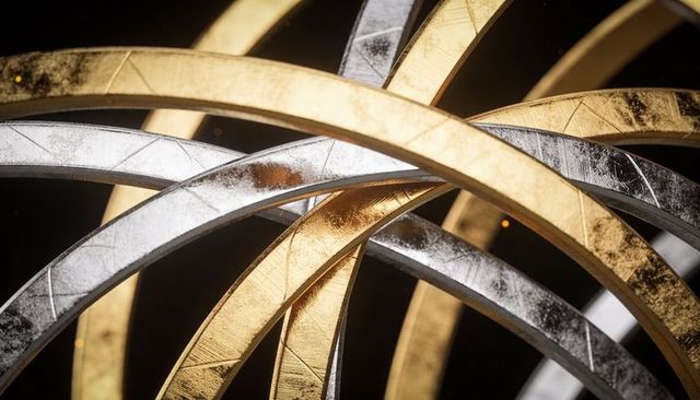 Interlocking gold silver metal rings with textured scratches and reflective highlights