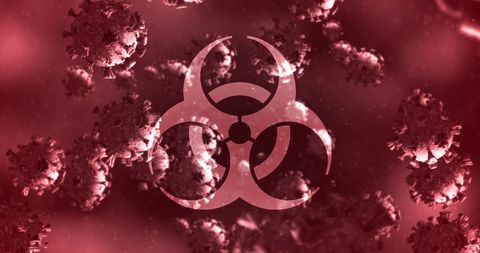 Covid-19 hazard symbol and virus cells on red background